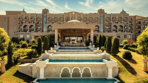A hotel with a central courtyard, a fountain, and a large building with multiple balconies.