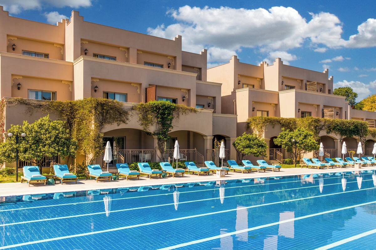 Ein Hotel mit Schwimmbad, mehreren Balkonen und Sitzgelegenheiten im Freien.