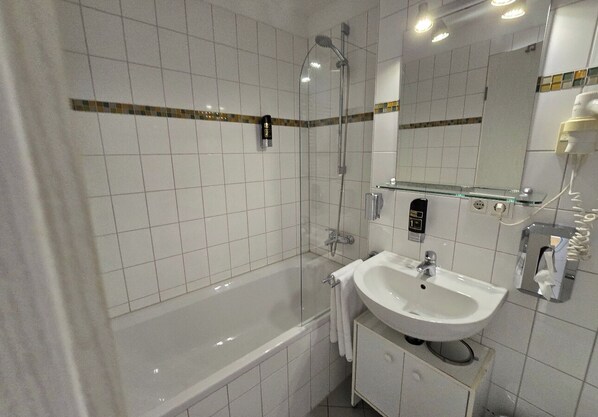 Un baño con bañera, lavamanos y espejo.
