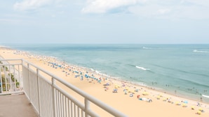 Une plage avec une barrière blanche, un rivage sablonneux et une eau d’un bleu limpide.