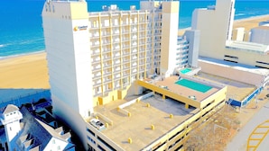 Un hôtel de grande hauteur doté de nombreux balcons, d’une piscine sur le toit et offrant une vue sur la plage.