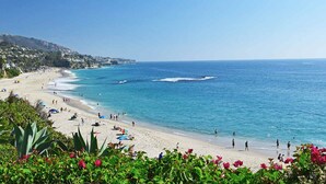 A coastal beach with clear blue waters, sandy shore, and lush greenery. - Hilton Garden Inn Irvine Spectrum Lake Forest (Lake Forest)