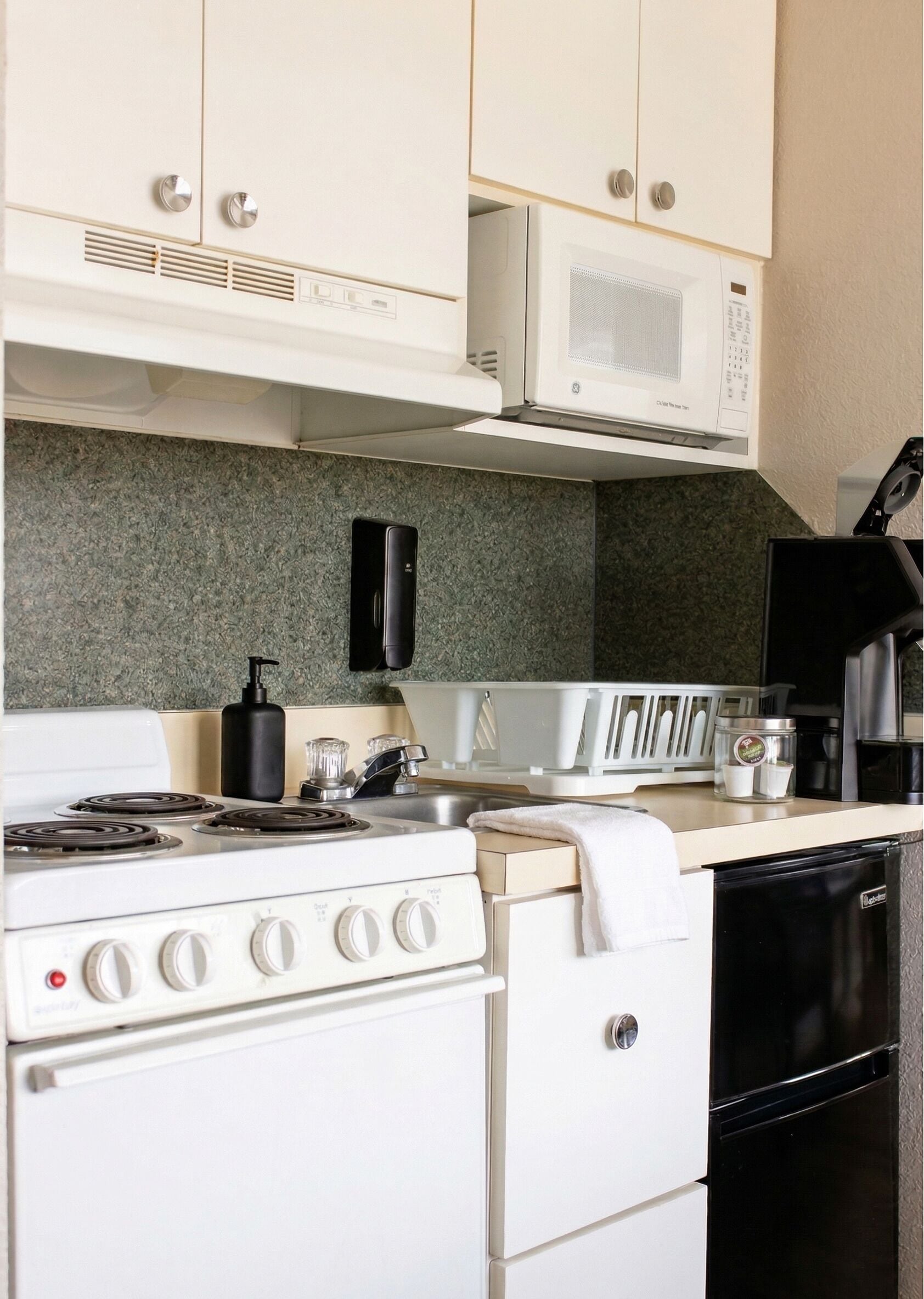 Una cocina equipada con estufa, microondas y lavavajillas.