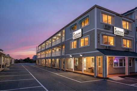 A two-story Seahorse Inn & Cottages with multiple rooms and a visible outdoor seating area.
