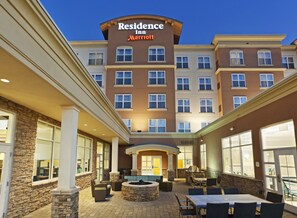 A hotel with a central courtyard, outdoor seating, and a pool area.