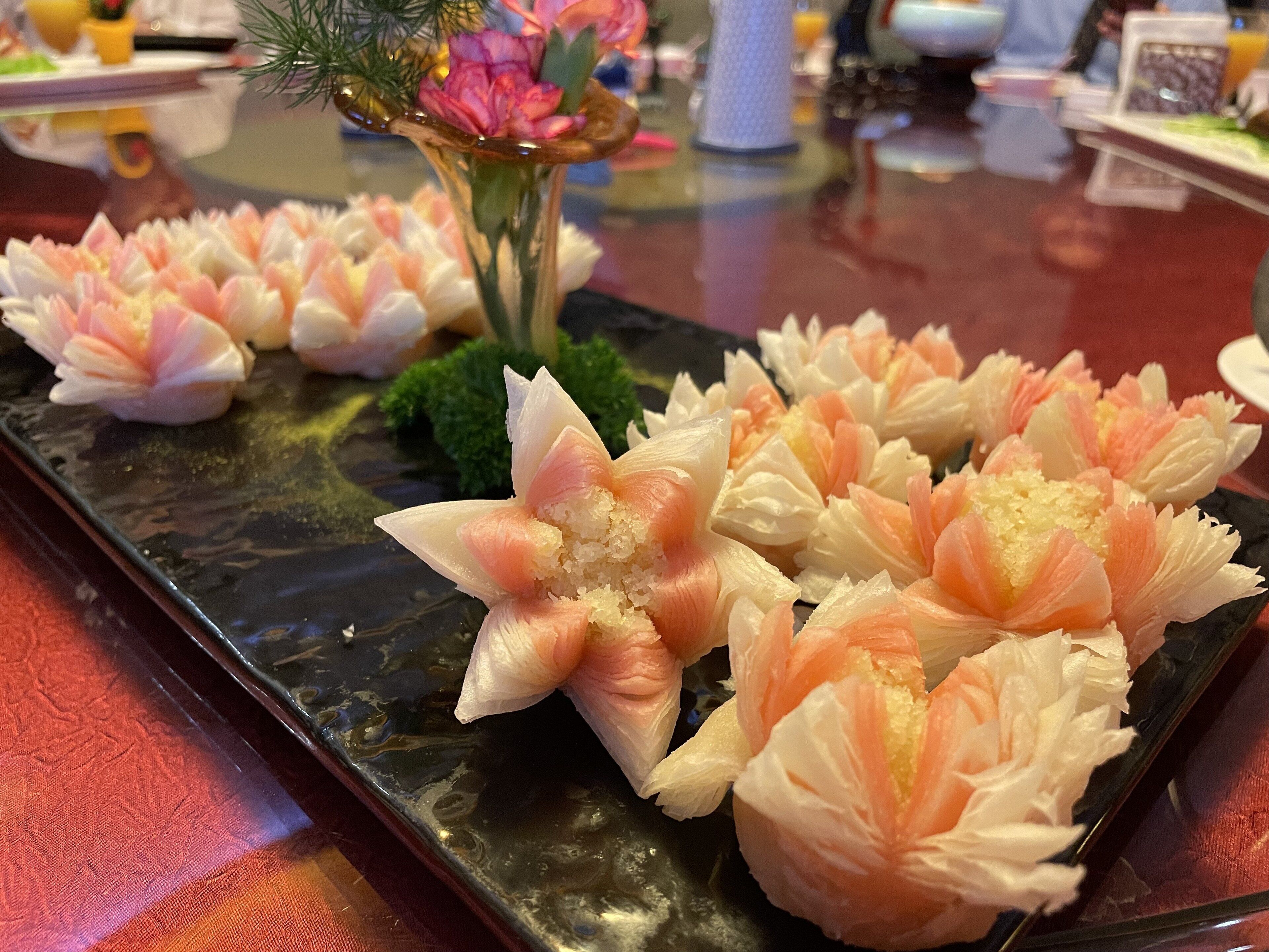 Un arreglo decorativo de flores sobre una bandeja negra.