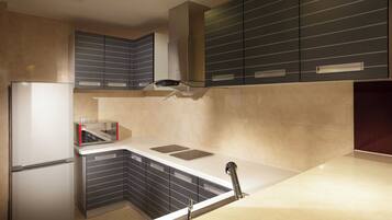 A compact kitchen with a built-in microwave, a small sink, and a refrigerator.