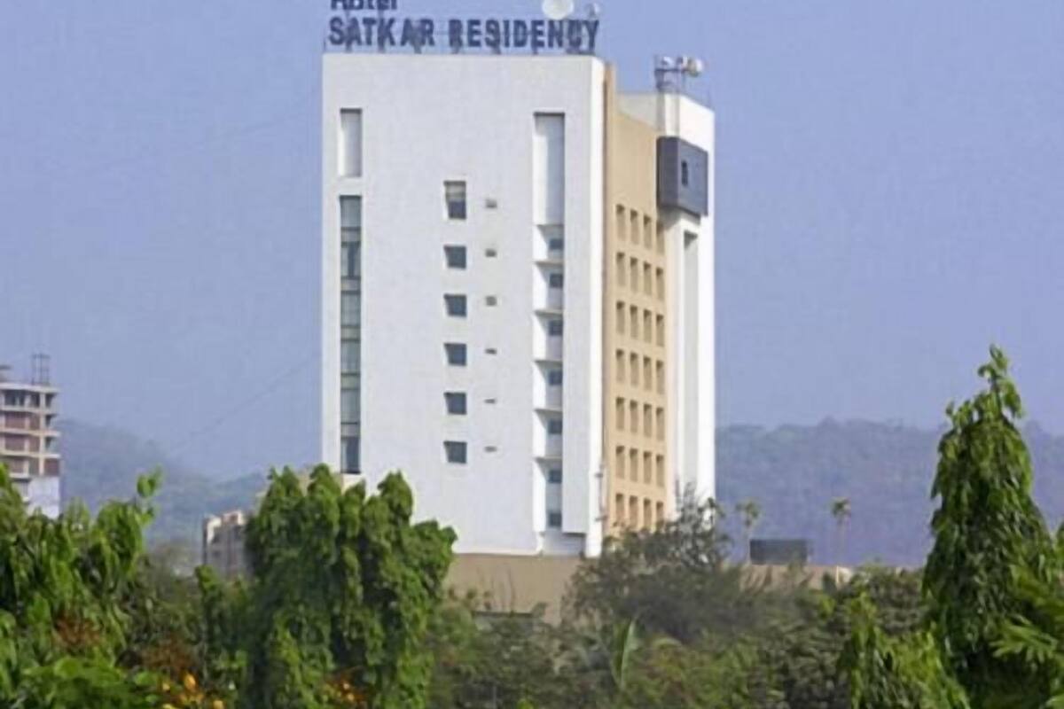 A tall, multi-story building with a sign reading 'Hotel SATKAR RESIDENCY.'