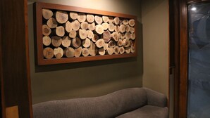 A wall-mounted log display in a room with a gray sofa. - Hotel Park Residency (New Delhi)