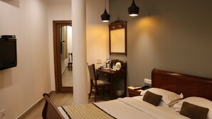A hotel room with a bed, a desk, a chair, a television, and a mirror. - Hotel Park Residency (New Delhi)