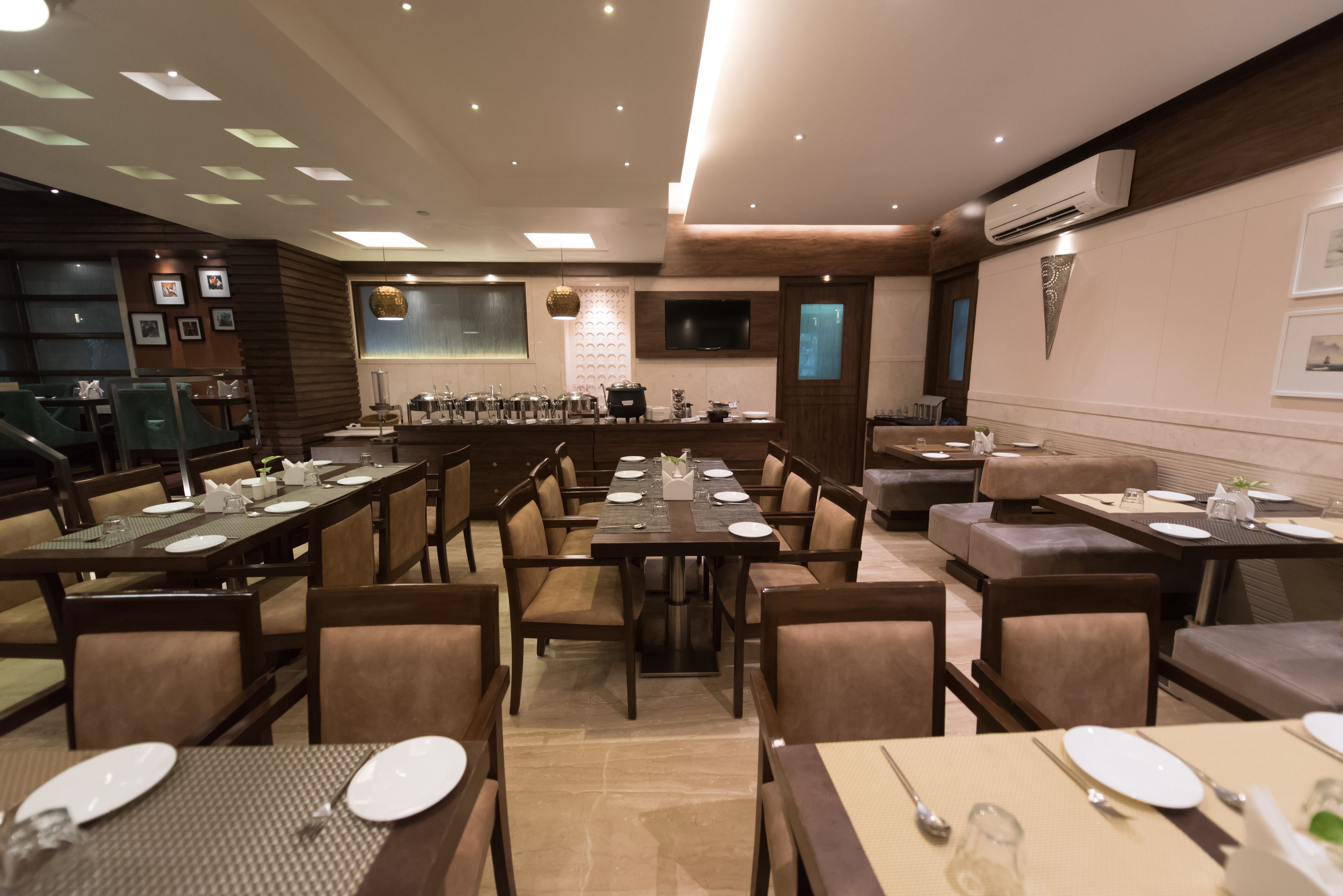 A restaurant with multiple dining tables and booths, equipped with table settings and chairs.