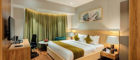 A hotel room with a bed, bedside table, lamp, chair, desk, and a television.