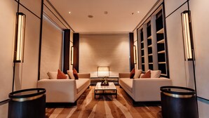 A modern hotel lobby with a central seating area, a large bookshelf, and a patterned floor. - Travancore Court (Kanayannur)