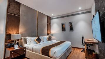 Una habitación de hotel moderna con una cama grande, mesitas de noche, un escritorio y un televisor.