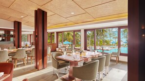 A spacious dining area with a pool view, featuring modern furniture and large windows. - The Resort Mumbai (Mumbai)