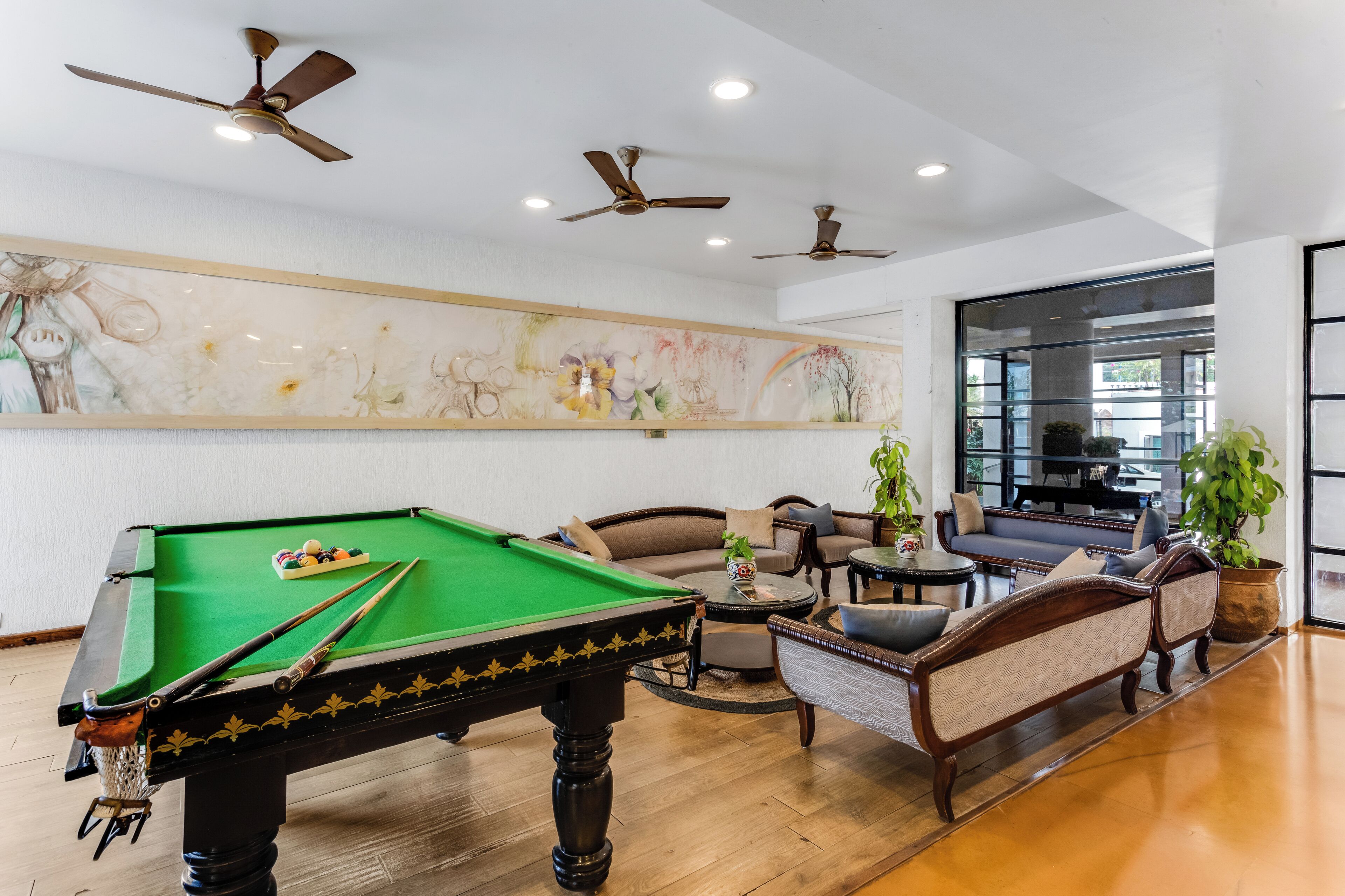 A pool table with a green felt surface, surrounded by a sofa set and a coffee table.
