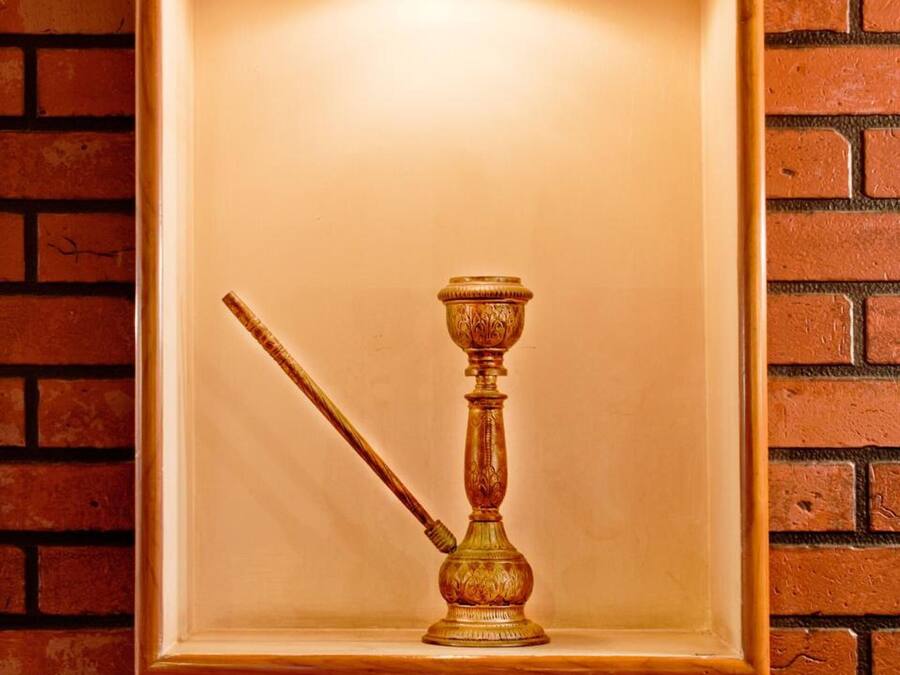 A framed object with a handle and a base, mounted on a brick wall.