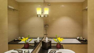 Un baño moderno con dos lavamanos, ducha y un espejo grande.
