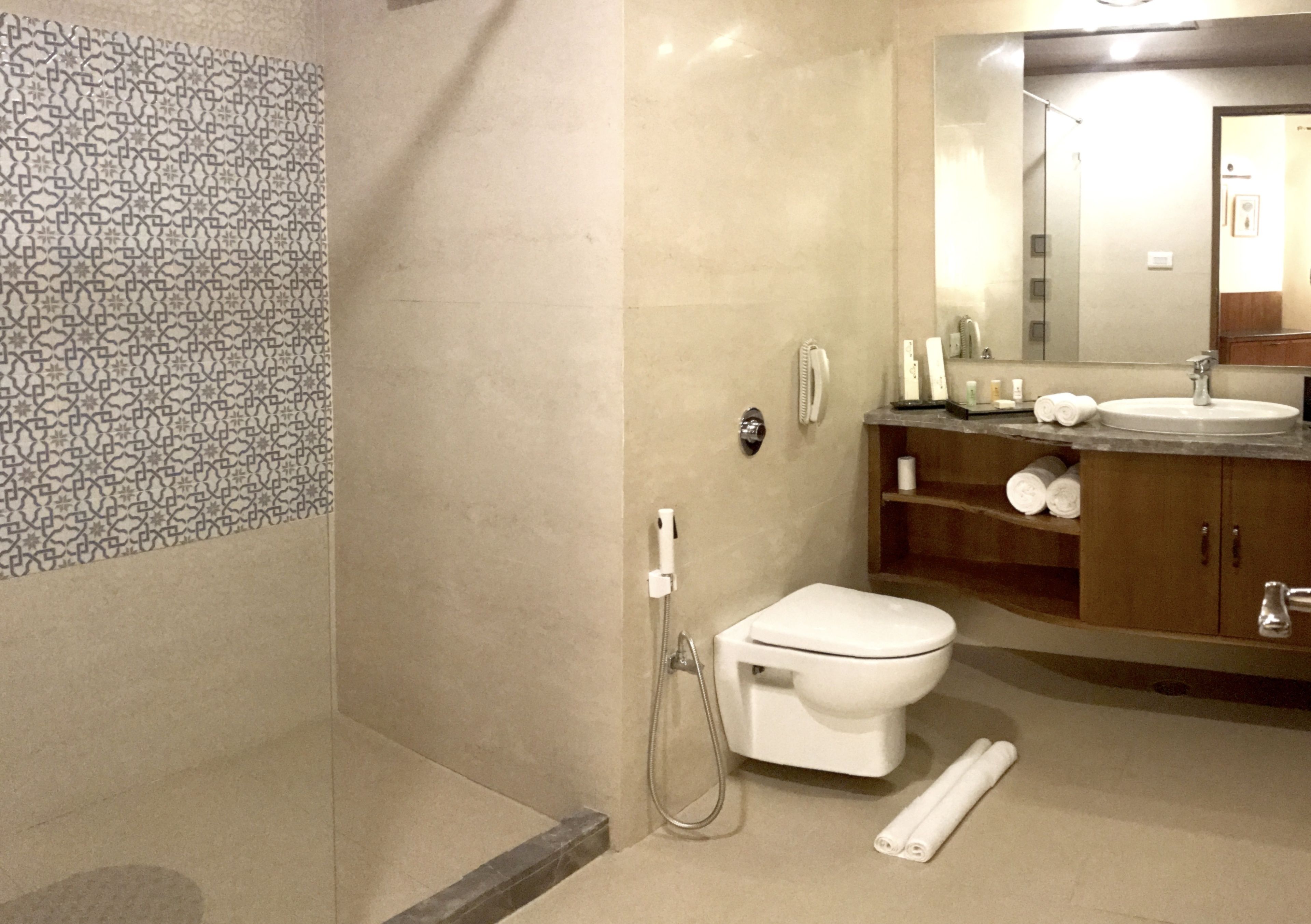 A modern bathroom with a shower, toilet, and sink.