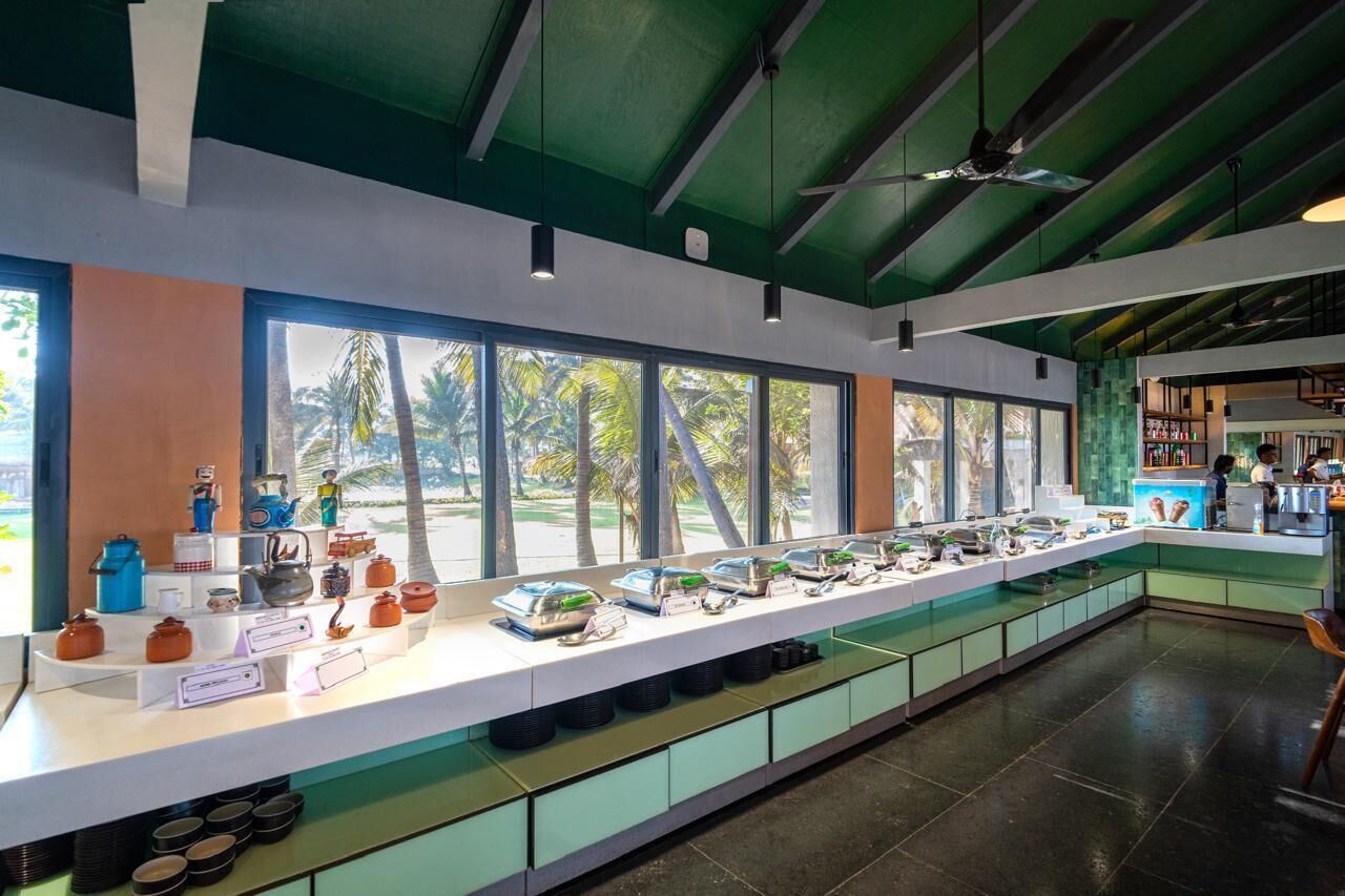 A long buffet counter with various food items and kitchen appliances.