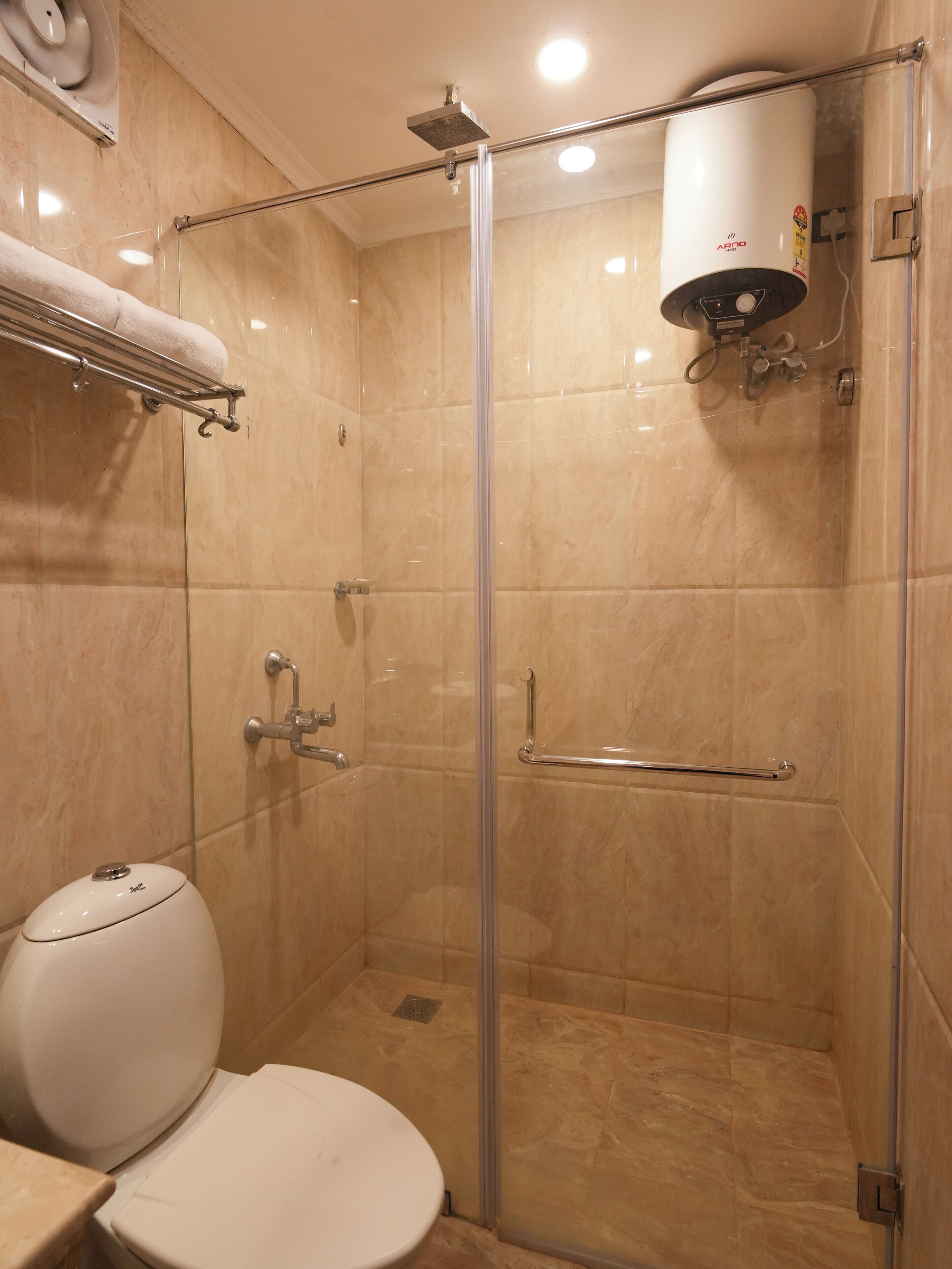 Un baño moderno con ducha de vidrio, inodoro y toallero.