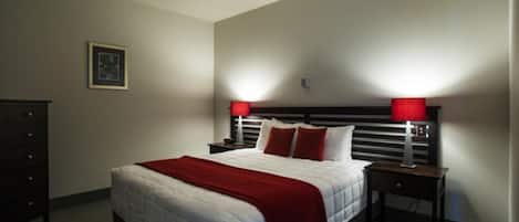 A neatly arranged bedroom with a large bed, two bedside tables, and a dresser.