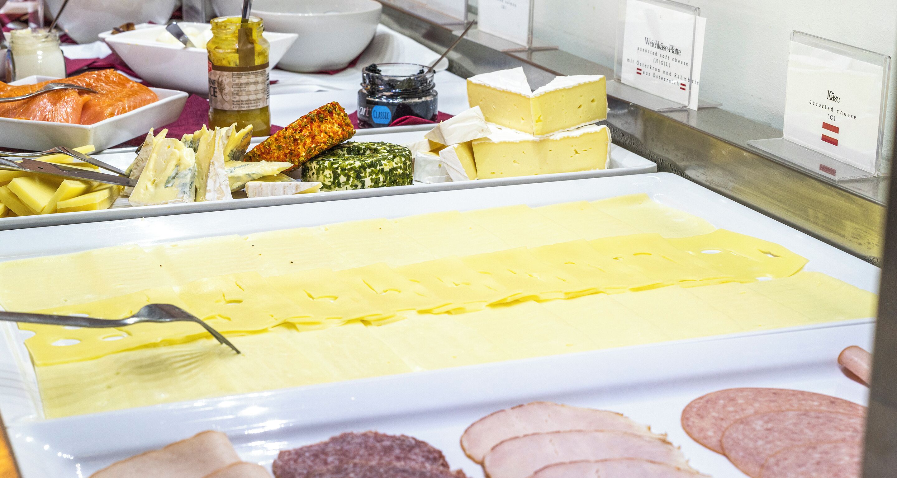 Un bufé de quesos y embutidos con distintas variedades de queso y fiambre.