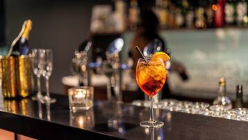 Eine Bar mit einem Cocktailglas, einer Champagnerflasche und einer Kerze.