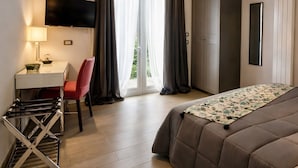 A bedroom with a bed, a desk, a chair, a TV, and a wardrobe. - Hotel Del Borgo (Sestri Levante)