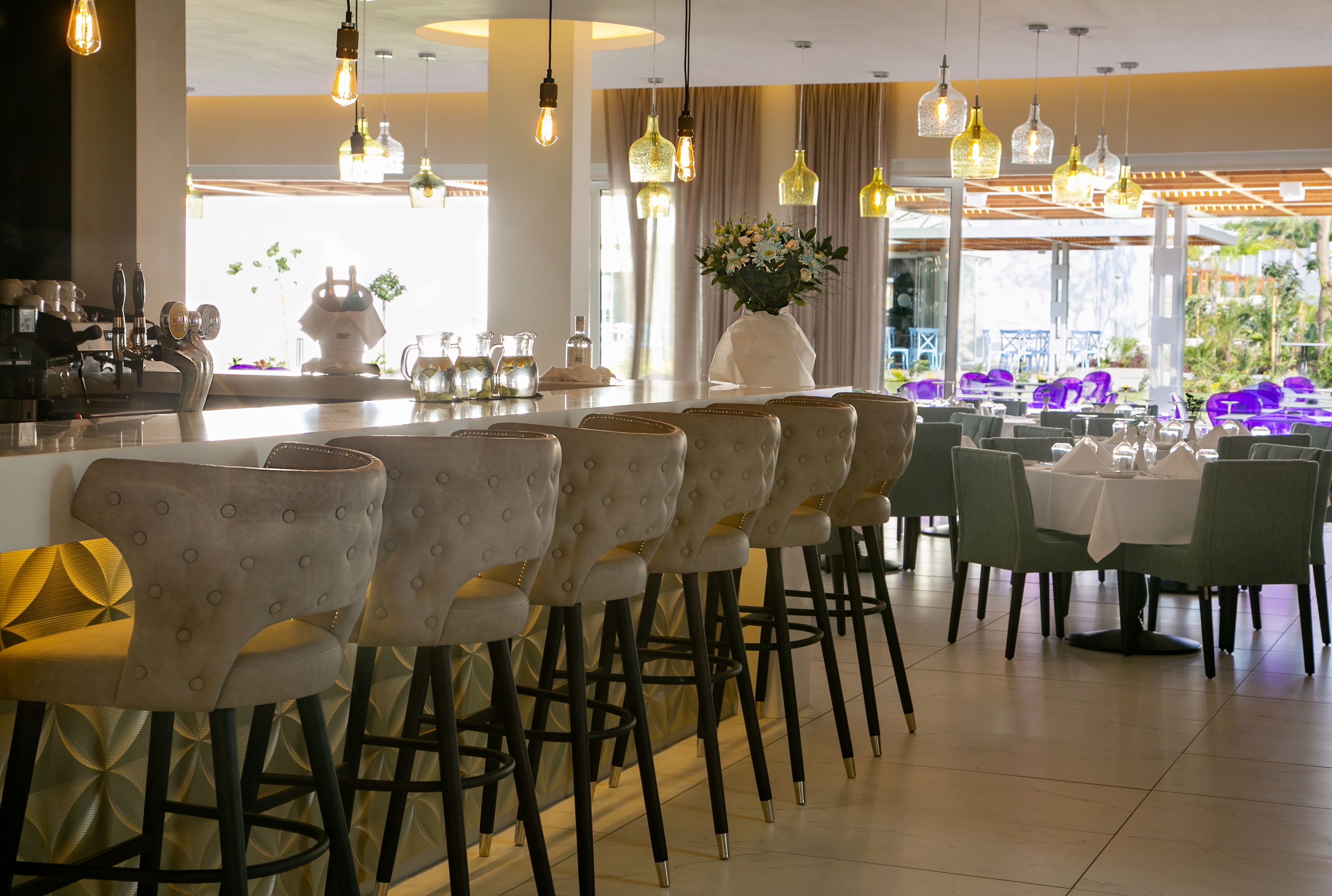 Un restaurant doté d’un bar, de chaises hautes et de tables aménagées pour le service.