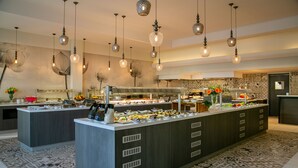 A modern kitchen with a central island, pendant lighting, and patterned tiles. - Vangelis Hotel & Suites (Paralimni)
