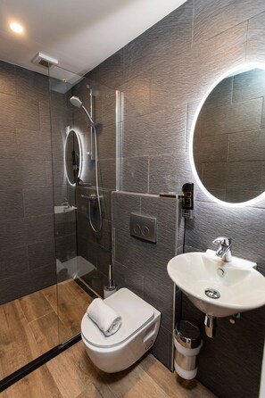 Standaard kamer | Badkamer | Een douche, een haardroger, handdoeken