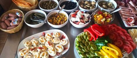 Une table de buffet proposant une variété de plats, notamment des légumes, des viandes et des salades.