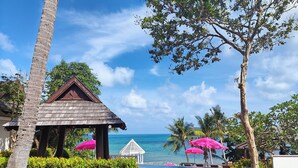 A beachside resort with a pool area, lounge chairs, and a gazebo. - Bhundhari Resort & Villas Samui (Koh Samui)