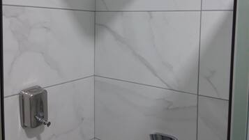 Een aparte badkuip en douche, een haardroger