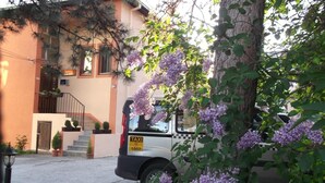 A taxi parked in front of a building with a staircase and potted plants. - Hotel Vila Silia (Skopje)