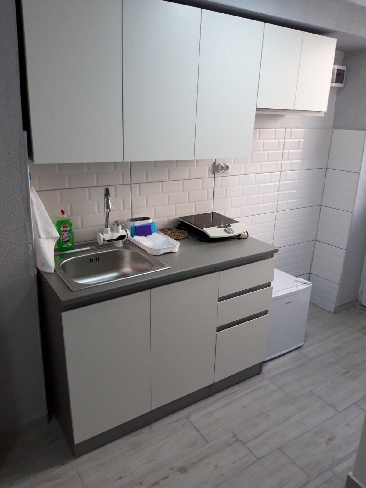 A modern kitchen with a built-in dishwasher, a sink, and a countertop with a scale.