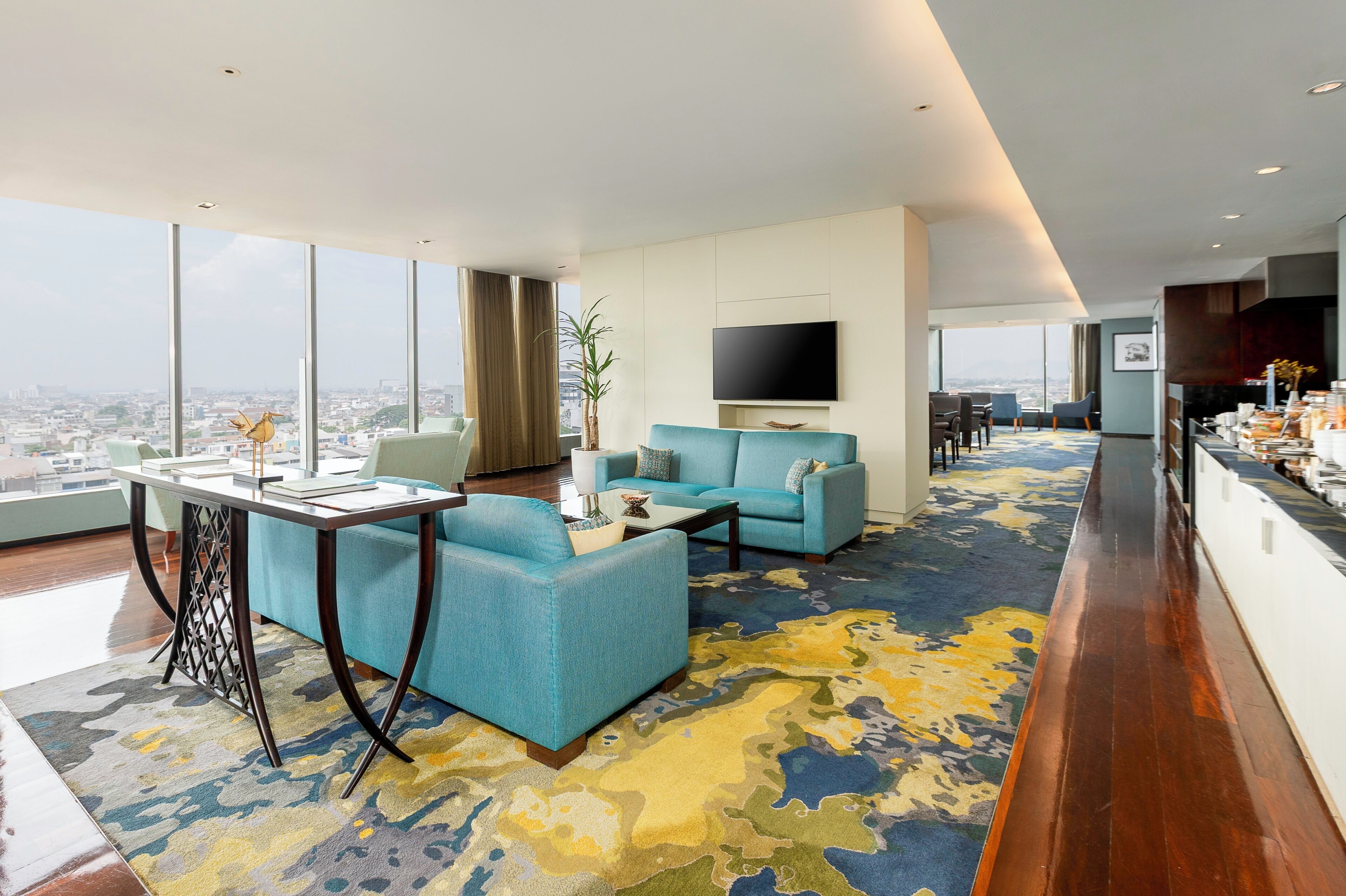 A modern living room with a sofa, a coffee table, and a TV mounted on the wall.