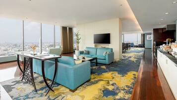 A modern living room with a sofa, a coffee table, and a TV mounted on the wall.