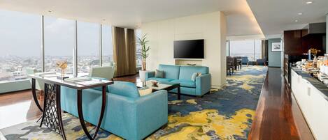 A modern living room with a sofa, a coffee table, and a TV mounted on the wall.