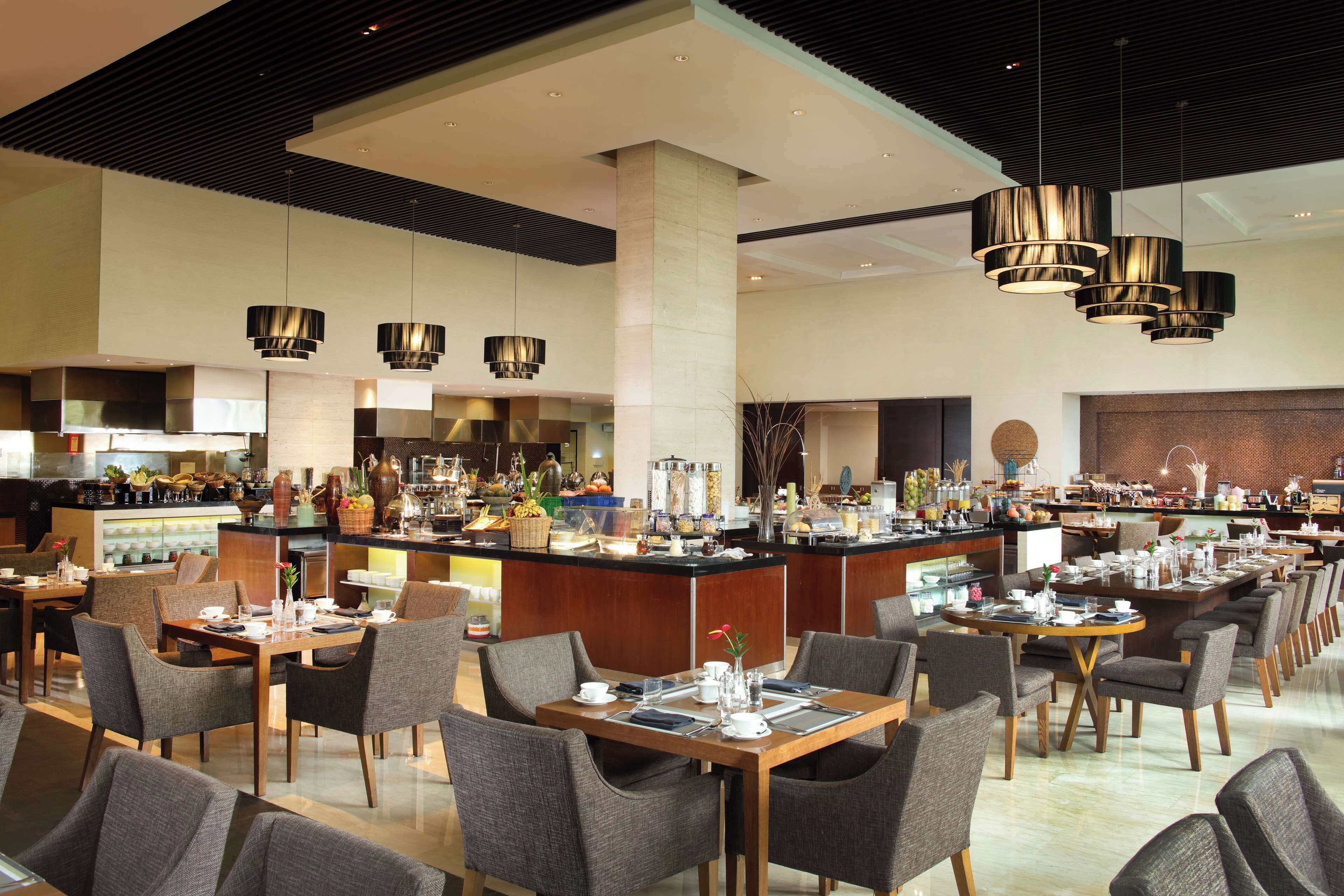 A spacious hotel lobby with multiple seating areas, a central bar, and a variety of amenities.