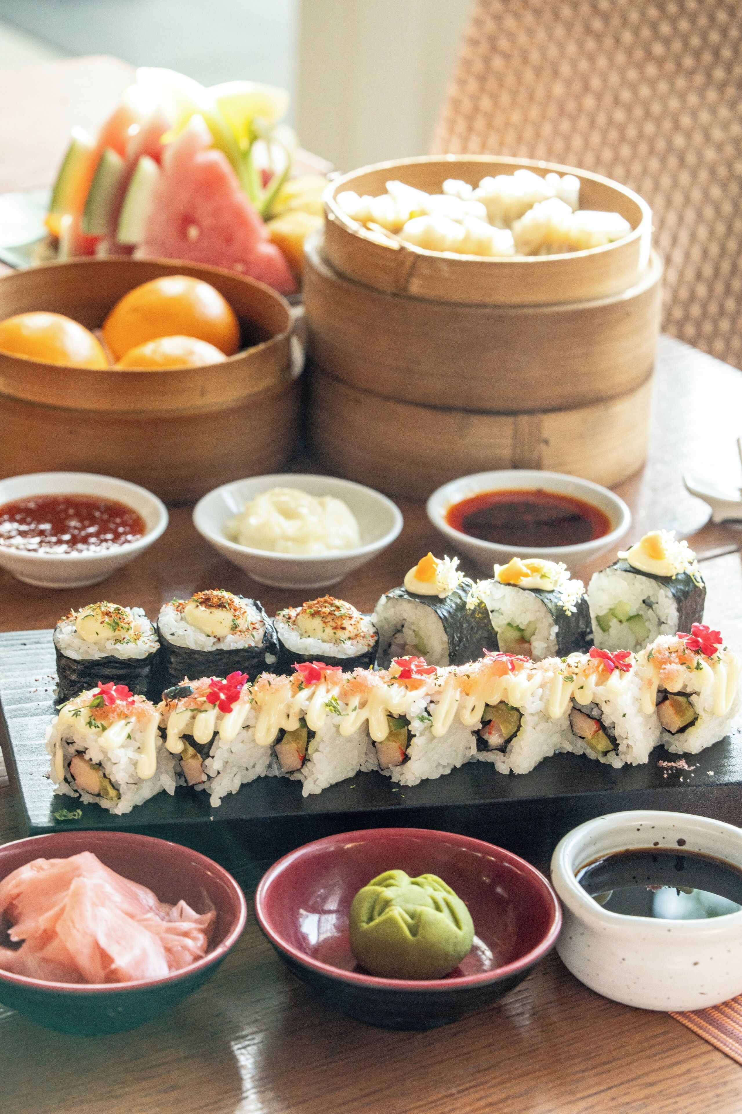 A variety of sushi and other dishes on a wooden table.