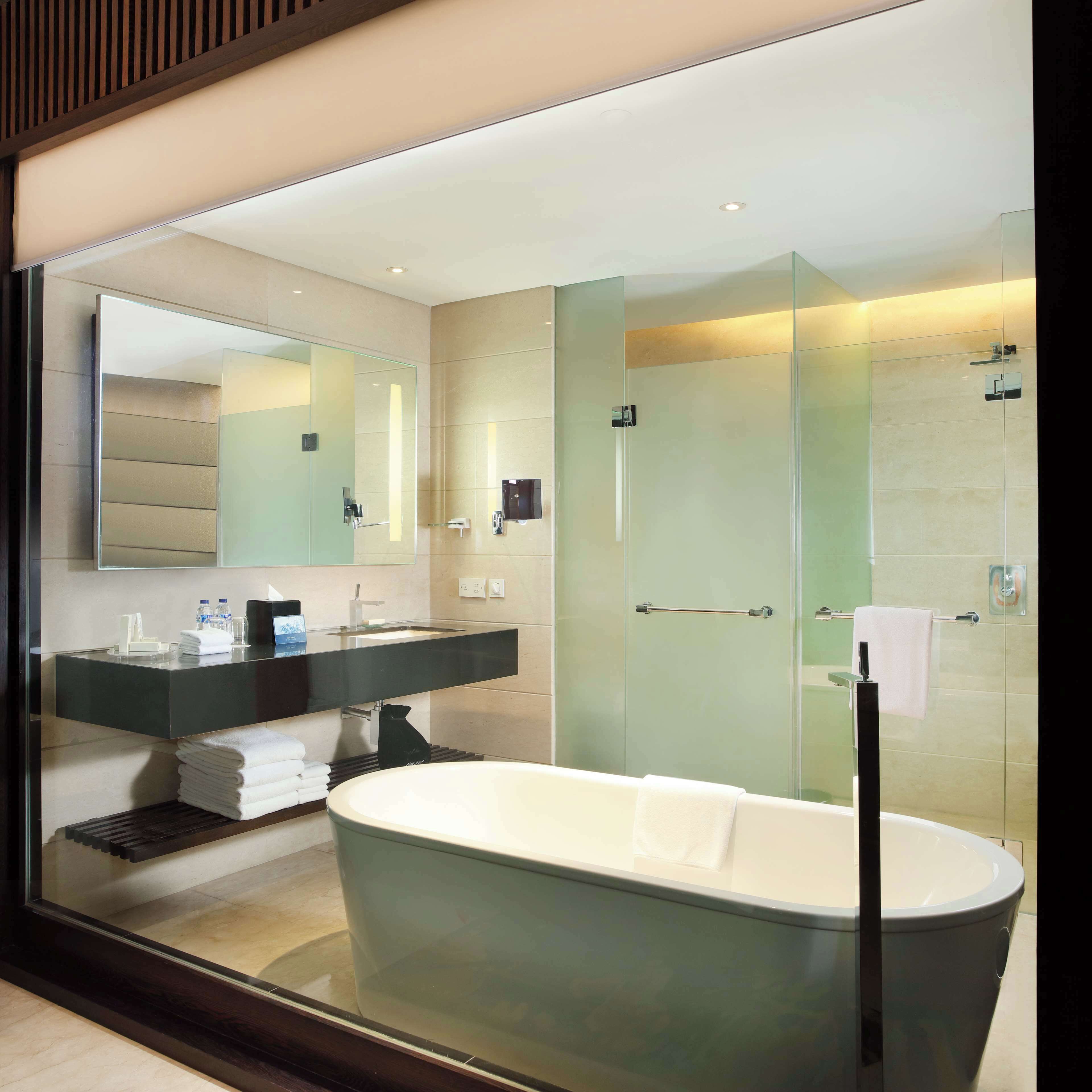 A modern bathroom with a freestanding bathtub, a glass-enclosed shower, and a vanity with a mirror and towel rack.
