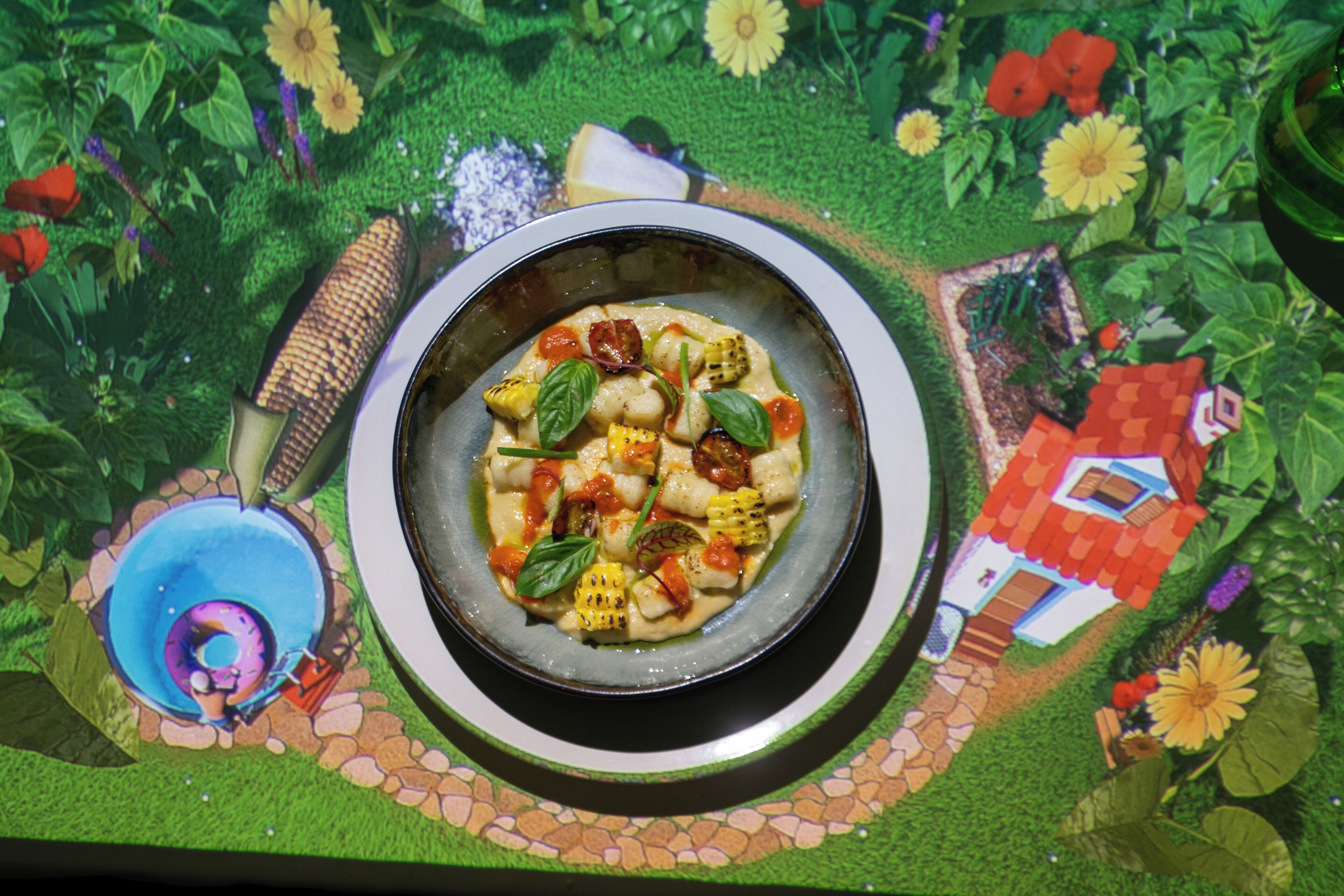 Un plato de comida sobre una mesa con mantel decorado con motivos de jardín.