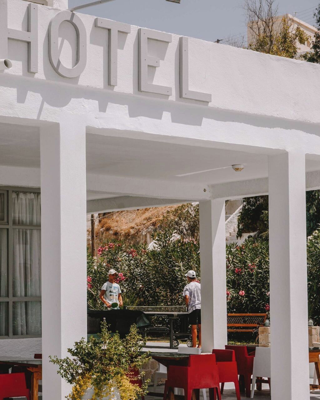 Een hotel met een witte gevel en een bord waarop 