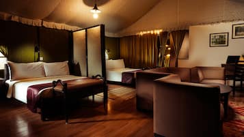 Una habitación de hotel con cama con dosel, un sofá, un escritorio y una silla.