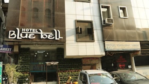 A hotel named "Blue Bell" with a modern facade, multiple windows, and a visible sign for "Honda Activia Parts". - Hotel Blue Bell (New Delhi)