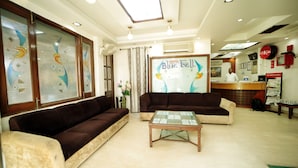A hotel lobby with two sofas, a coffee table, and a reception desk. - Hotel Blue Bell (New Delhi)