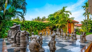 A chessboard with statues in a tropical garden setting. - Resort Terra Paraiso (Calangute)