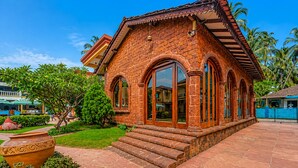 A brick building with arched windows and a tiled roof. - Resort Terra Paraiso (Calangute)